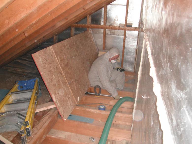 An Orange Energy crew member installs cellulose insulation in the attic space after air sealing.